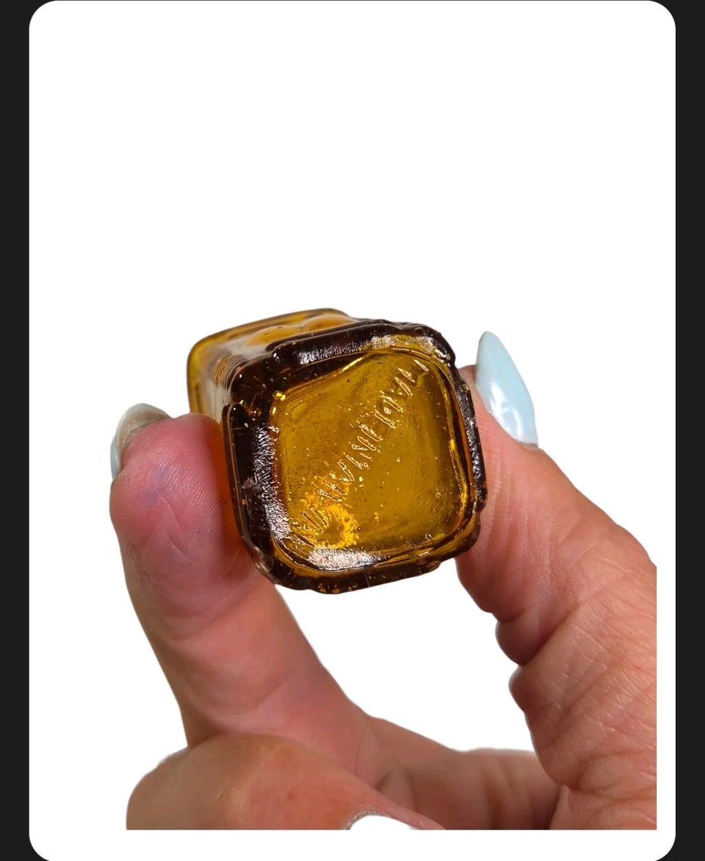Oddly Darling Vintage miniature square amber glass apothecary bottle base with embossed lettering held in hand