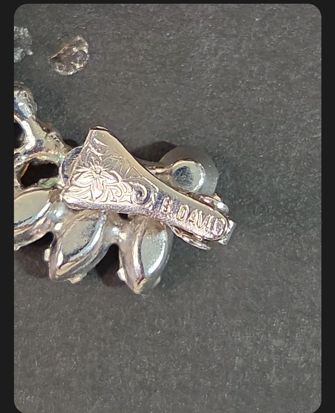 Oddly Darling Vintage B. David clip-on earring back showing floral engraving and signature hallmark on silver-tone metal