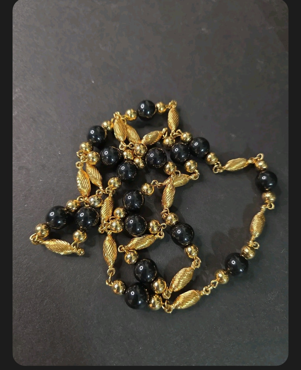 Oddly Darling Vintage long necklace featuring polished black beads and textured gold-tone metal spacers.