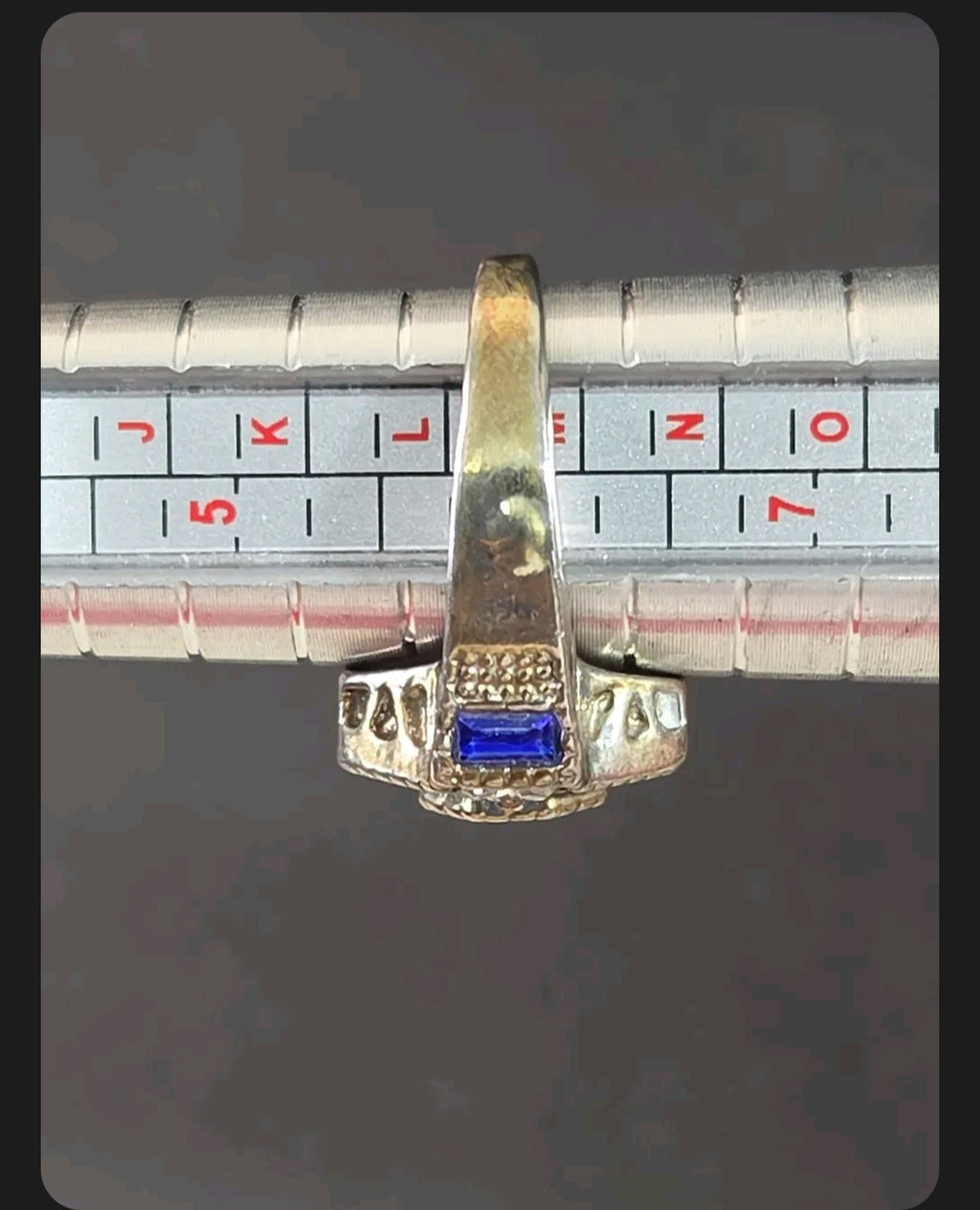 Oddly Darling Vintage ornate statement ring with a blue baguette stone on a metal ring sizing mandrel
