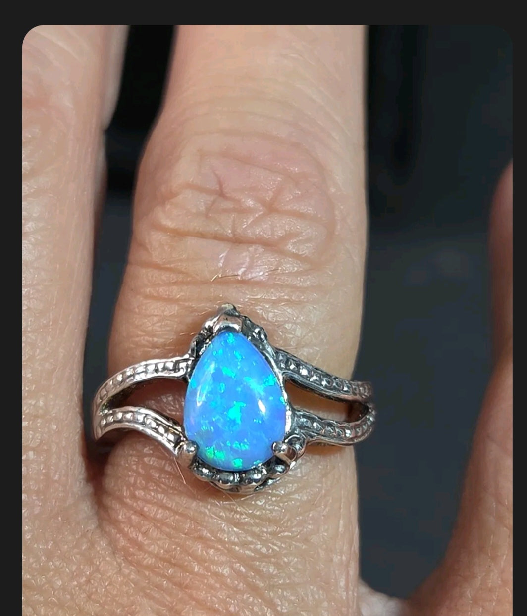 Oddly Darling Vintage pear-shaped blue opal statement ring with a textured silver split-shank band on a finger.