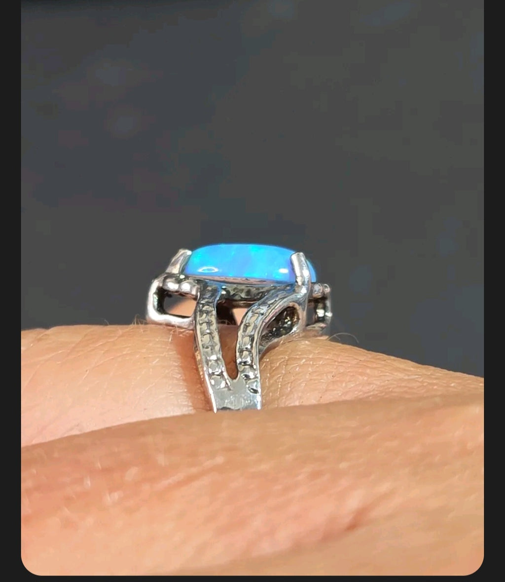 Oddly Darling Vintage pear-shaped blue opal statement ring with a textured silver-tone split-shank band on a finger.