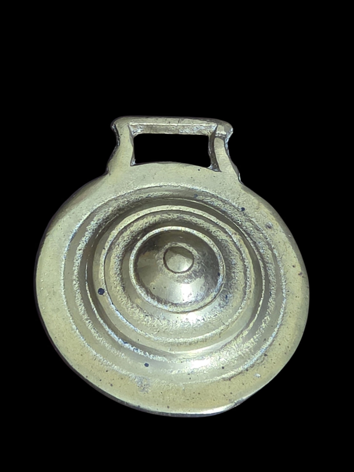 Oddly Darling Vintage brass horse harness medallion with concentric ring design and warm patina on black background