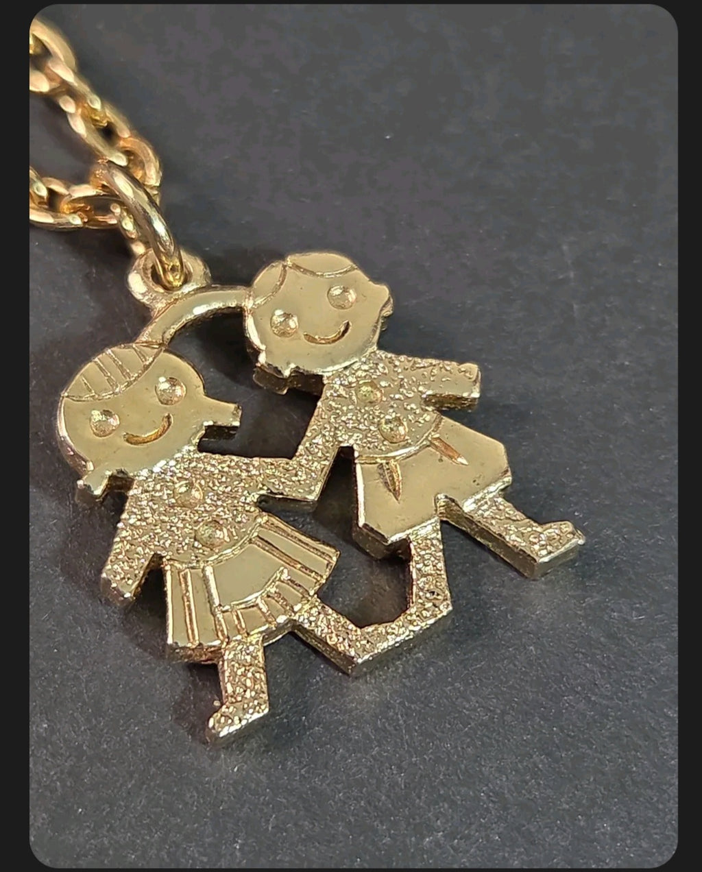 Oddly Darling Vintage gold-tone necklace featuring a textured pendant of two children holding hands on a link chain.
