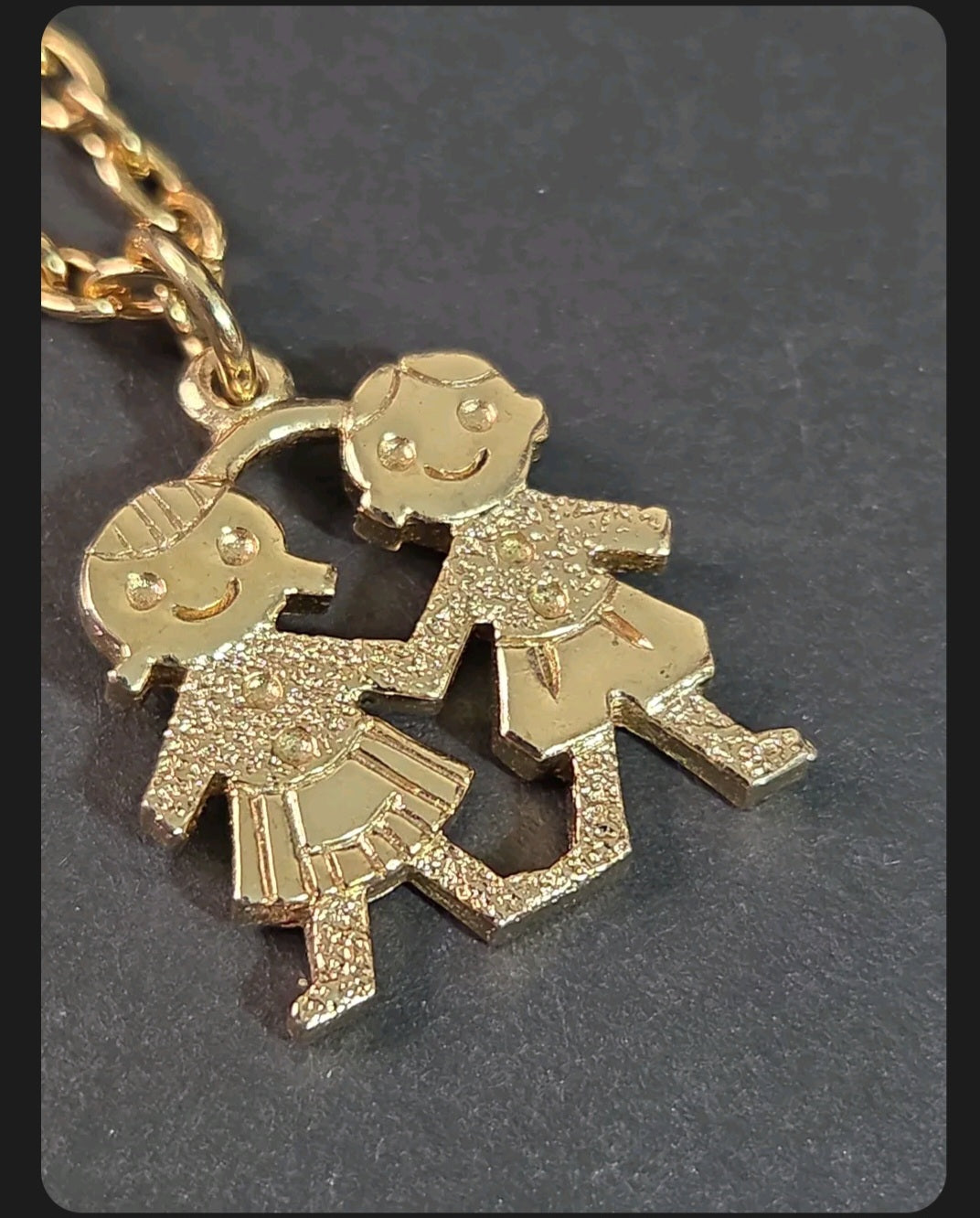Oddly Darling Vintage gold-tone necklace featuring a textured pendant of two children holding hands on a link chain.