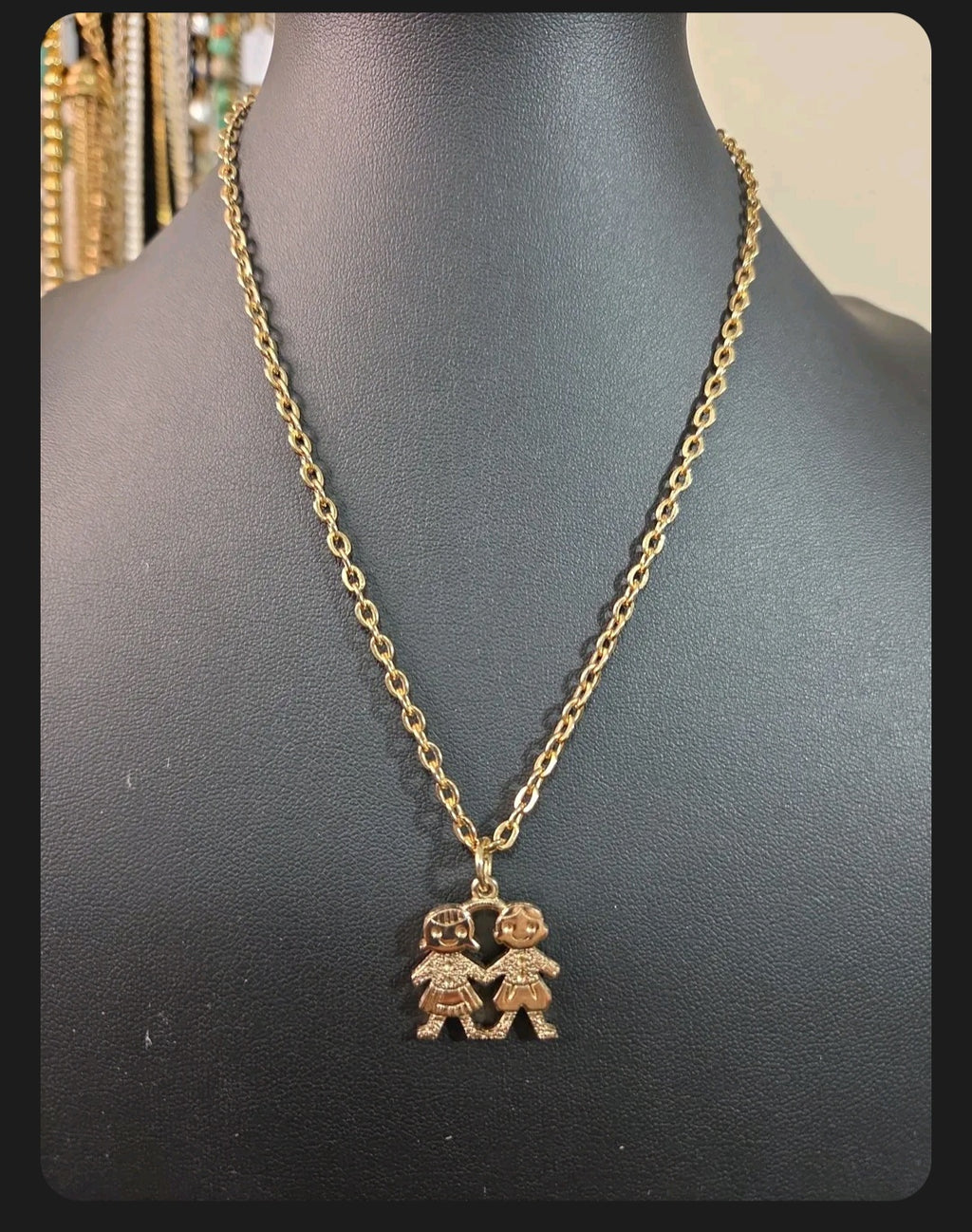 Oddly Darling Vintage gold-tone necklace featuring a pendant of two children holding hands on a delicate chain.