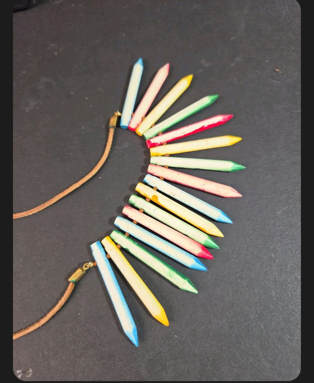 Oddly Darling Vintage statement necklace featuring colorful crayon-shaped pendants on a natural leather cord.