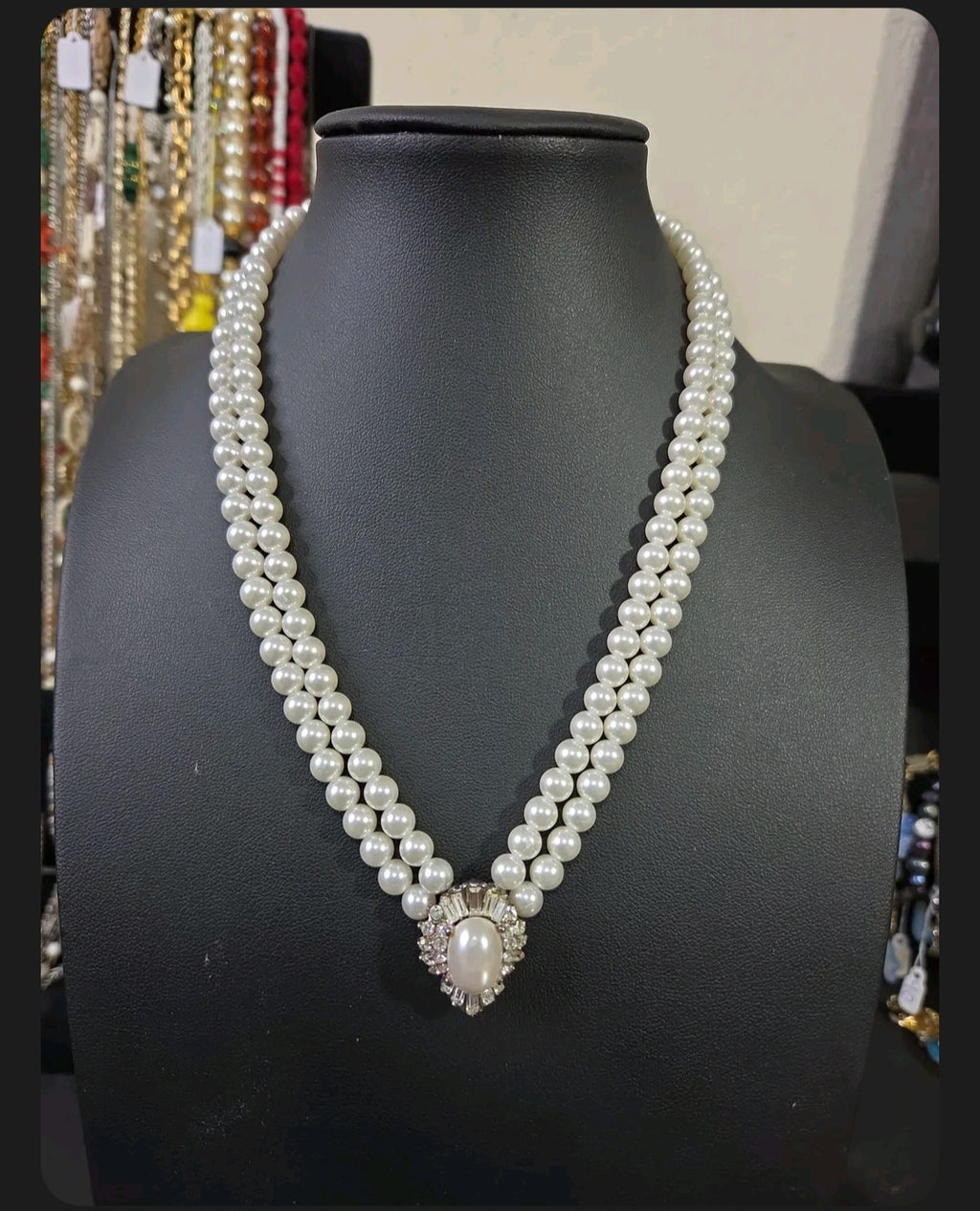 Oddly Darling Vintage double-strand cream faux pearl necklace with a crystal-encrusted oval pendant on a display bust.