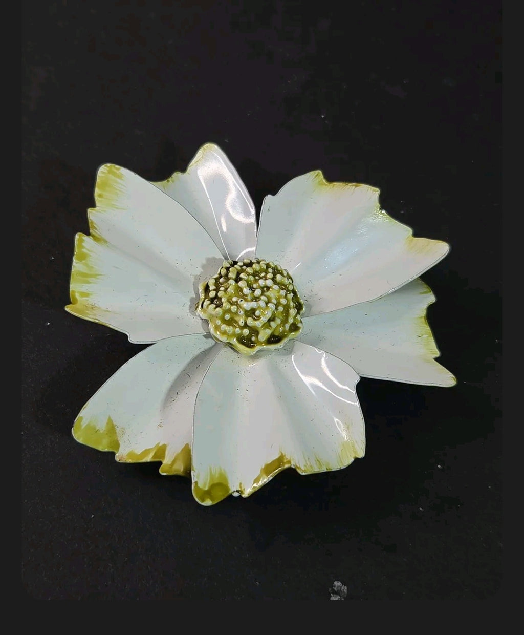 Oddly Darling Vintage enamel flower brooch with white petals, green tips, and a textured beaded center on black.