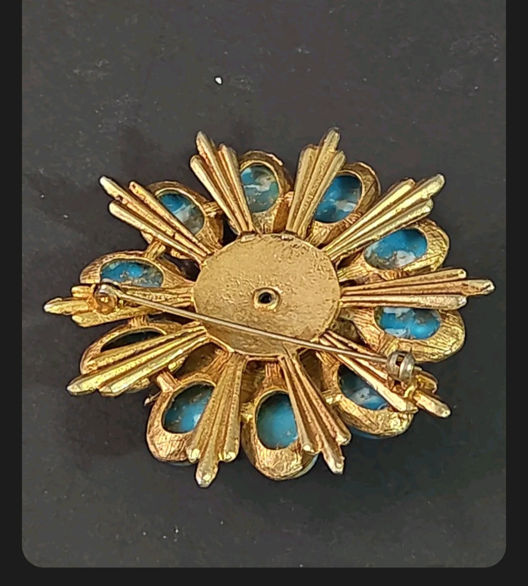 Back view of an Oddly Darling Vintage floral brooch featuring a brushed gold sunburst design and turquoise stones.