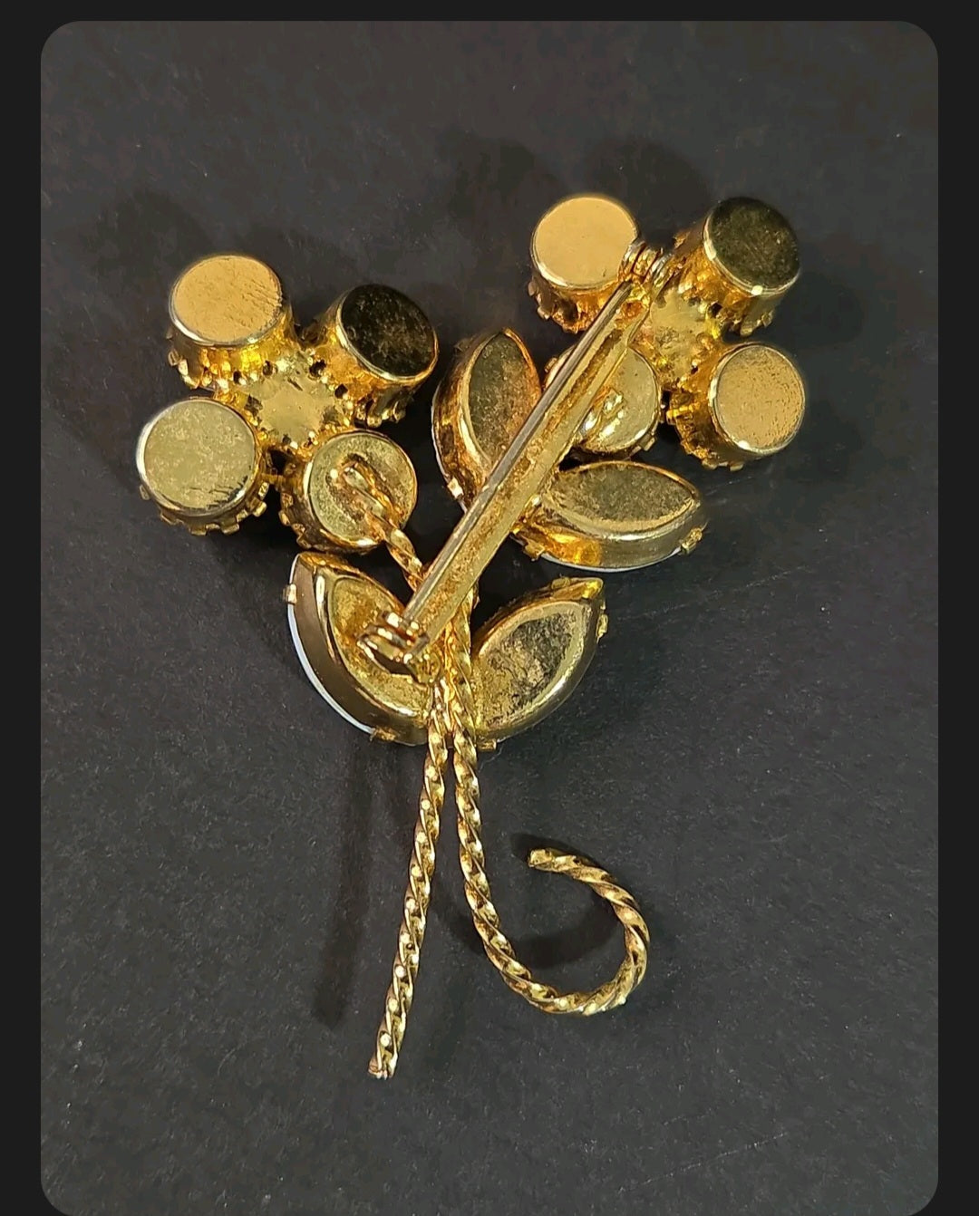 Back view of an Oddly Darling Vintage floral brooch showing the gold-tone metal setting and secure pin closure.