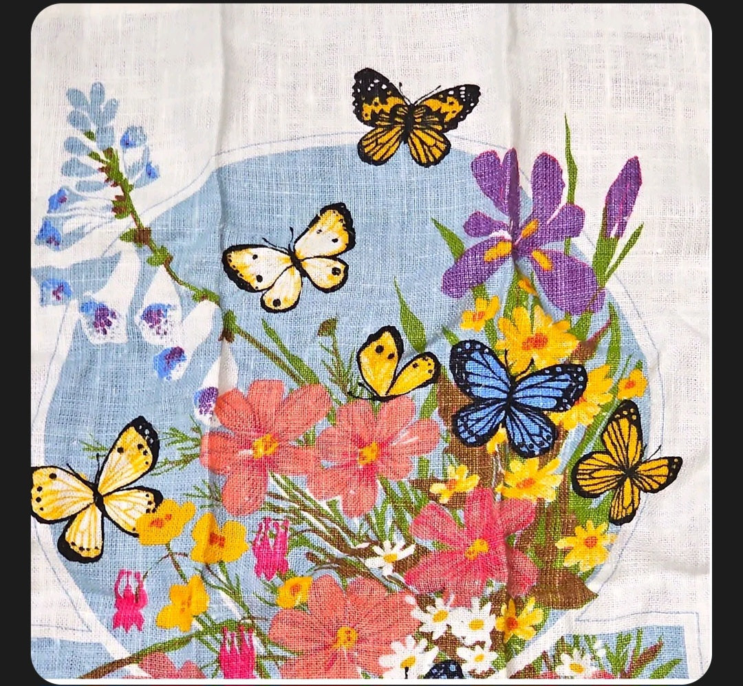 Oddly Darling Vintage linen tea towel with a colorful wildflower bouquet and butterfly print on a white background