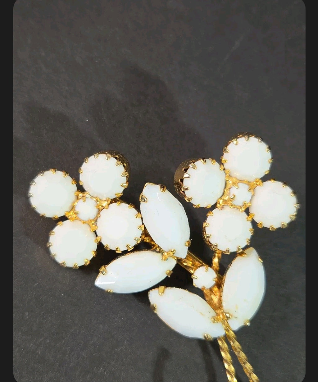 Oddly Darling Vintage floral brooch featuring white cabochon flower clusters and marquise leaves in a gold-tone setting.