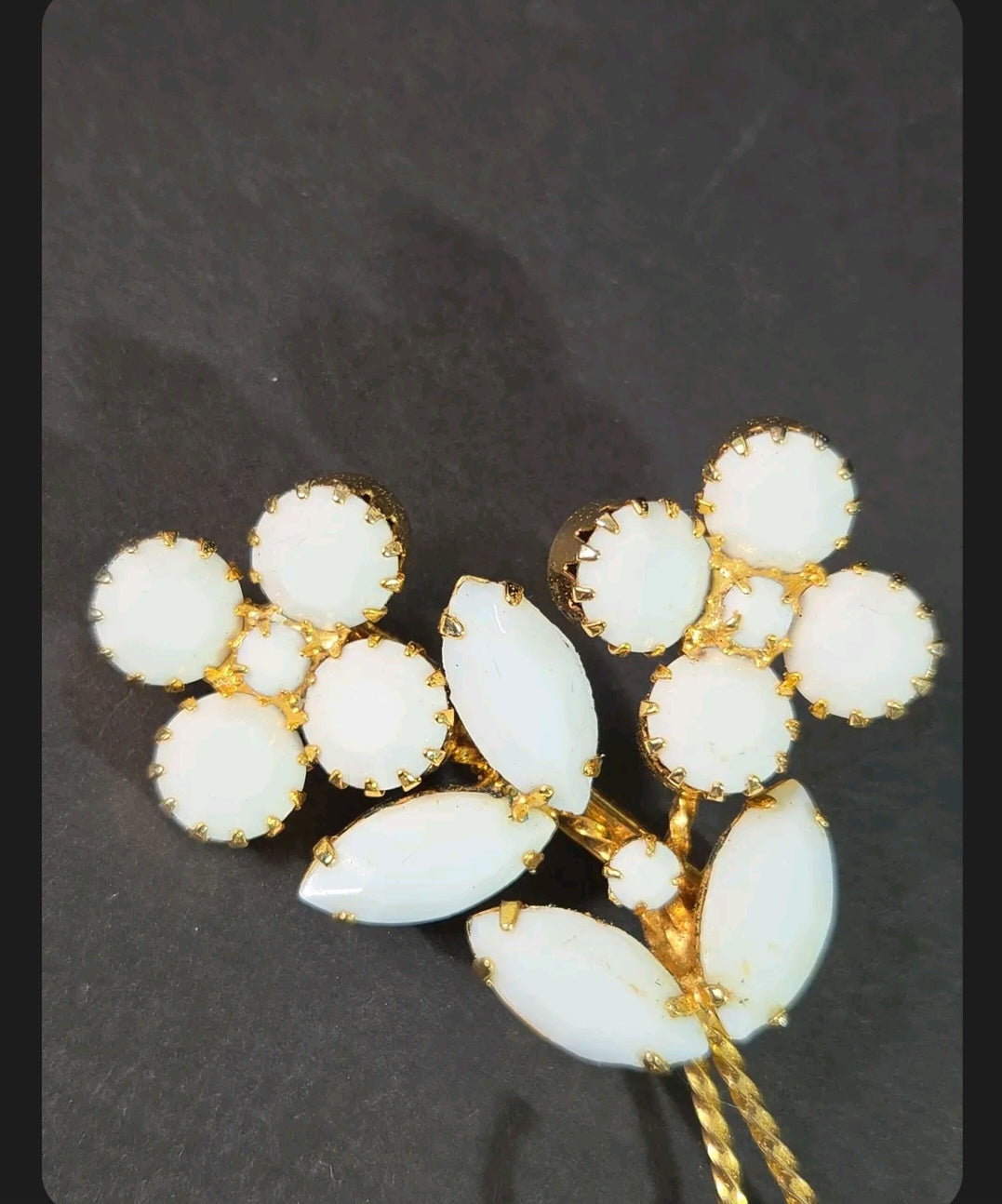 Oddly Darling Vintage floral brooch featuring white cabochon flower clusters and marquise leaves in a gold-tone setting.