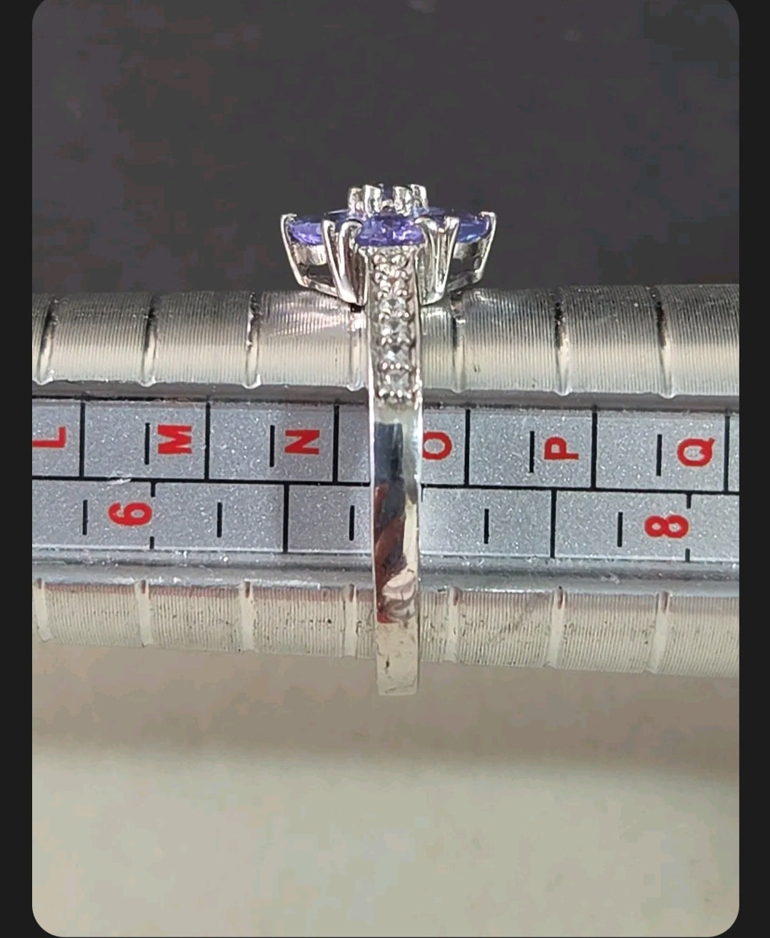 Oddly Darling Vintage floral cluster ring with violet gemstones and accent stones on a metal ring sizing mandrel