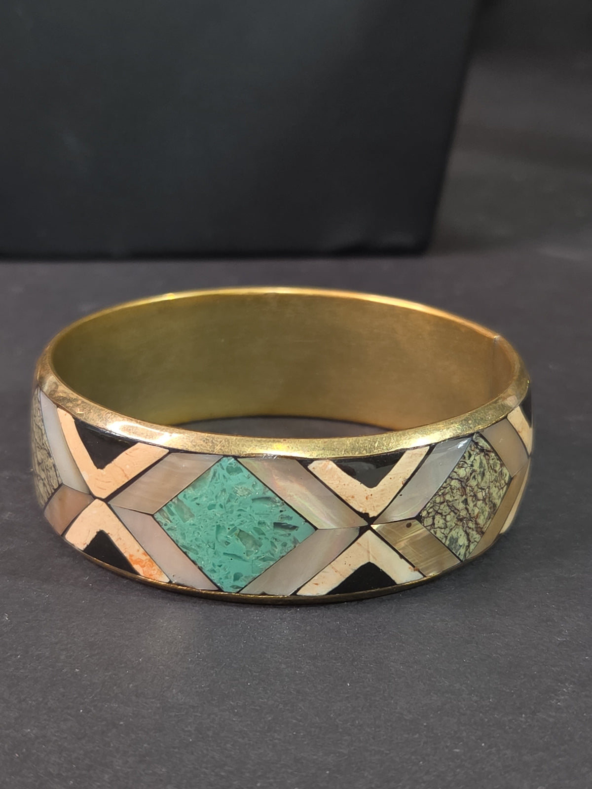 Oddly Darling Vintage geometric bangle with mother-of-pearl, turquoise, and stone inlay in a gold-tone metal frame.