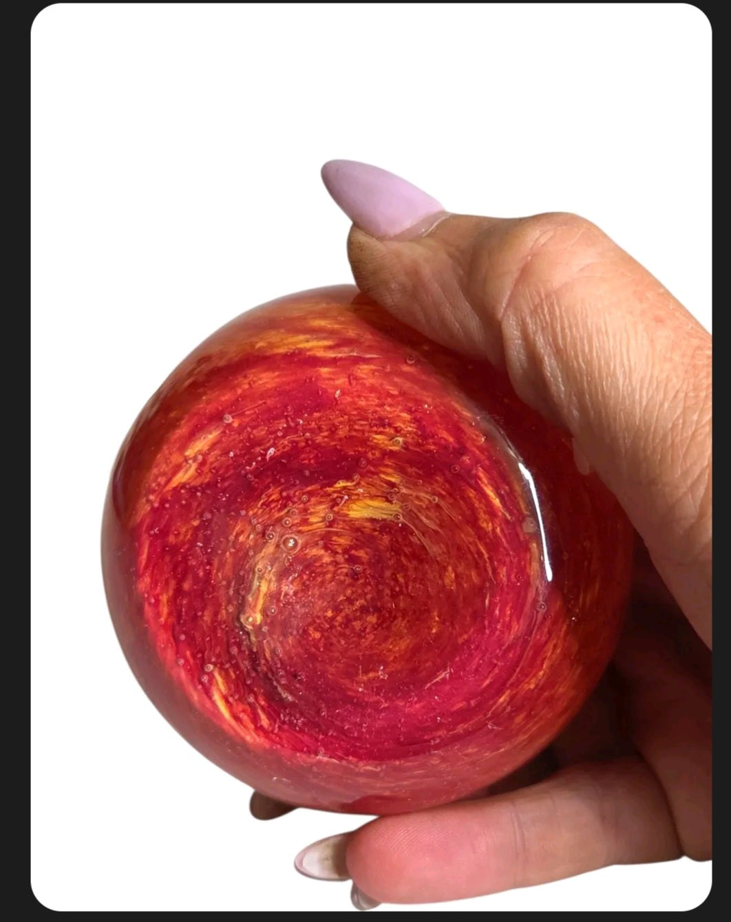 Oddly Darling Vintage hand blown glass fruit paperweight featuring a vibrant red and orange sunset swirl pattern.