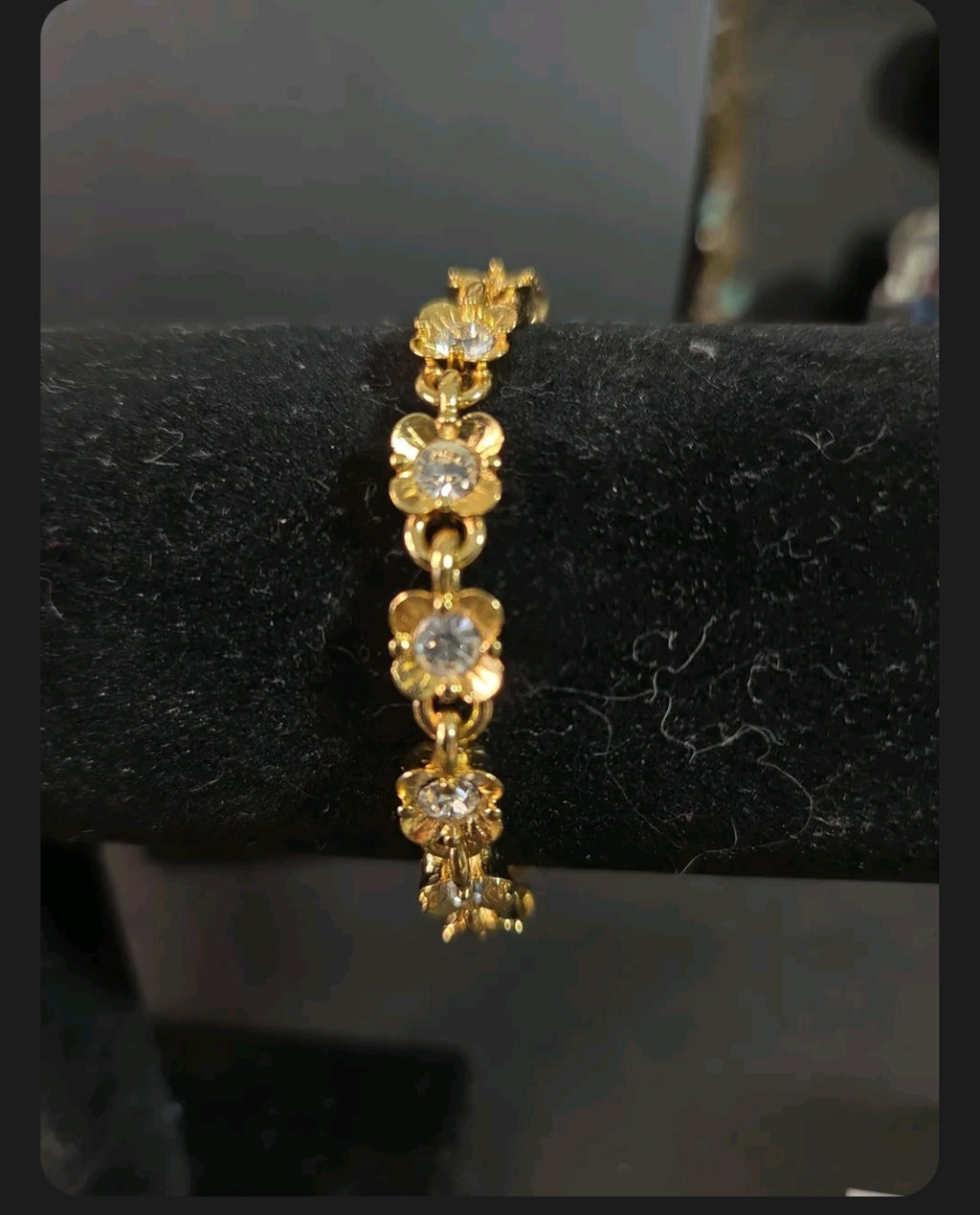 Oddly Darling Vintage gold-tone floral link bracelet featuring sparkling clear crystals on a black display stand.