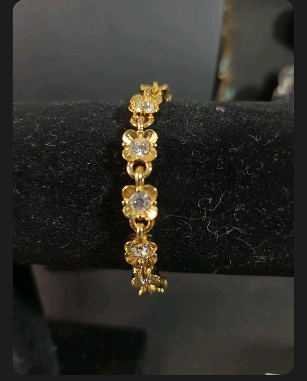 Oddly Darling Vintage gold-tone floral link bracelet featuring sparkling clear crystals on a black display stand.