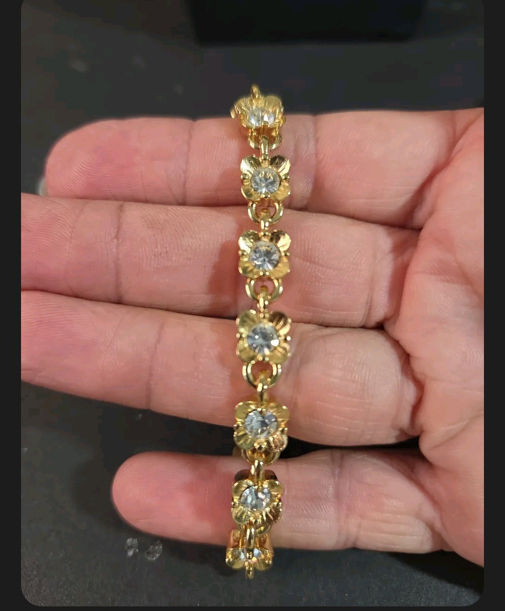 Oddly Darling Vintage gold-tone floral link bracelet with clear crystal centers held in a hand