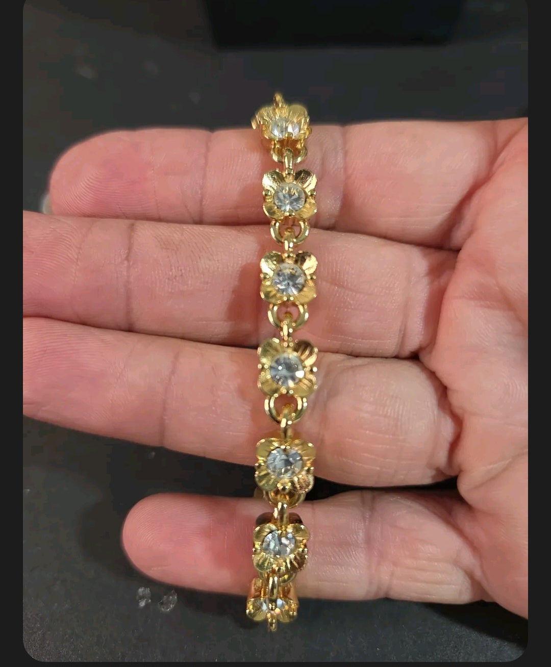 Oddly Darling Vintage gold-tone floral link bracelet with clear crystal centers held in a hand