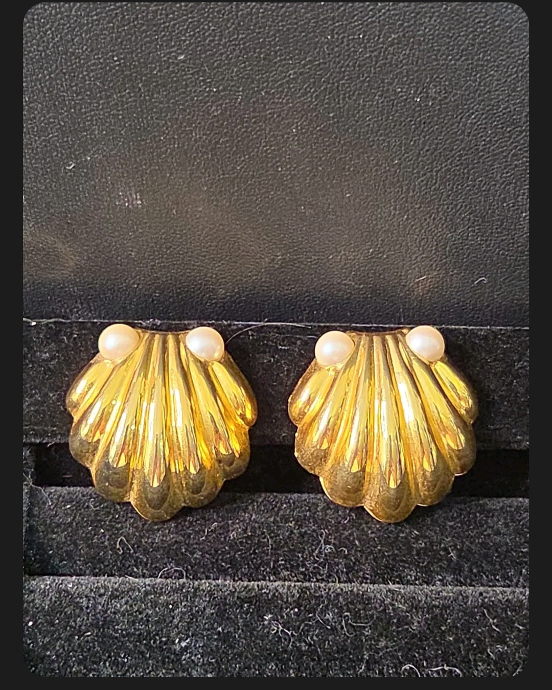 Oddly Darling Vintage gold-tone scalloped shell clip-on earrings with faux pearl accents on a black velvet display.