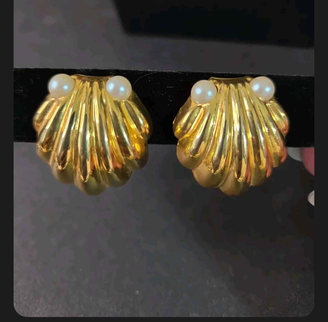 Oddly Darling Vintage gold-tone scalloped shell clip-on earrings with faux pearl accents on a black display stand.