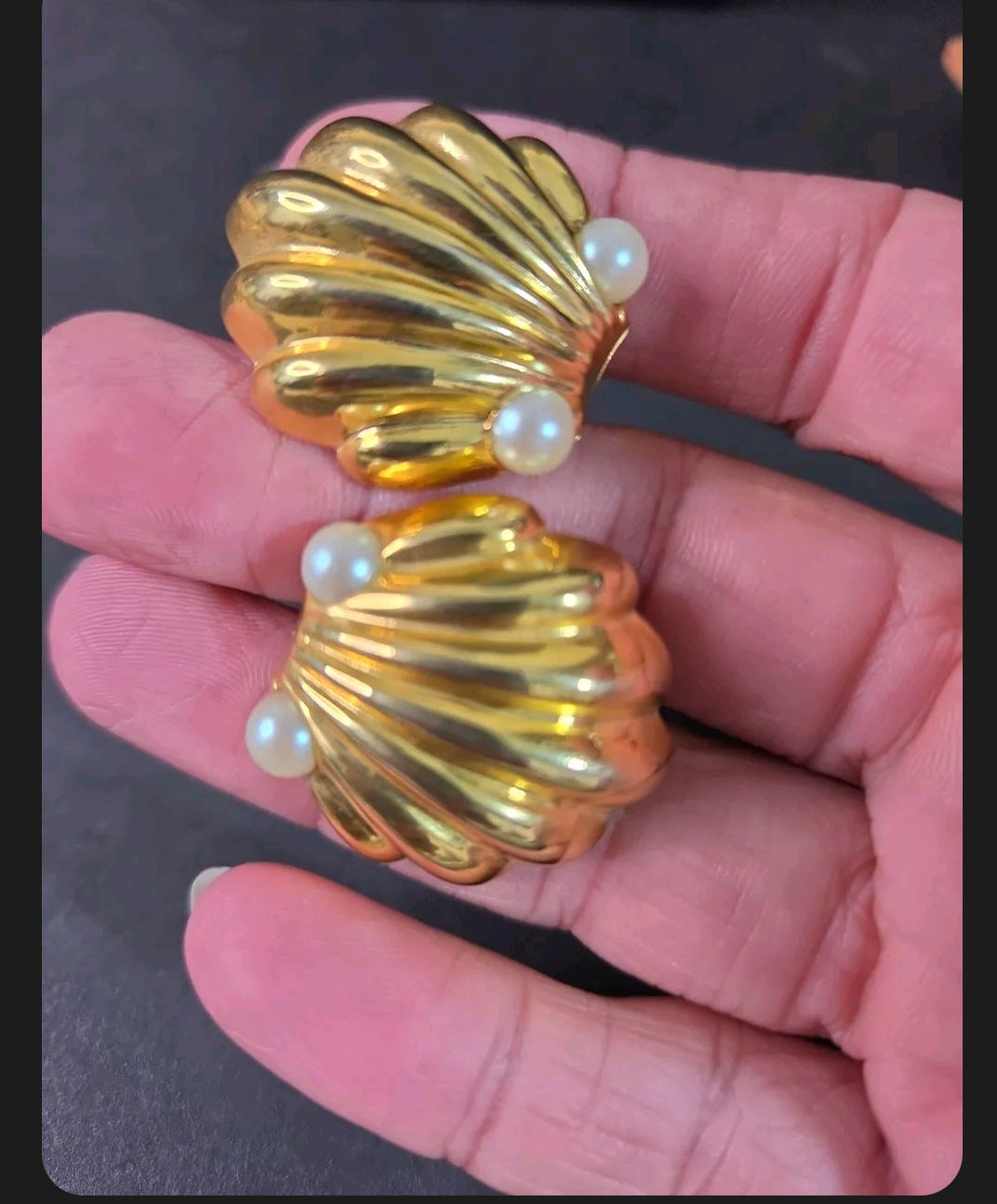 Oddly Darling Vintage gold-tone scalloped shell clip-on earrings with two faux pearls held in a hand