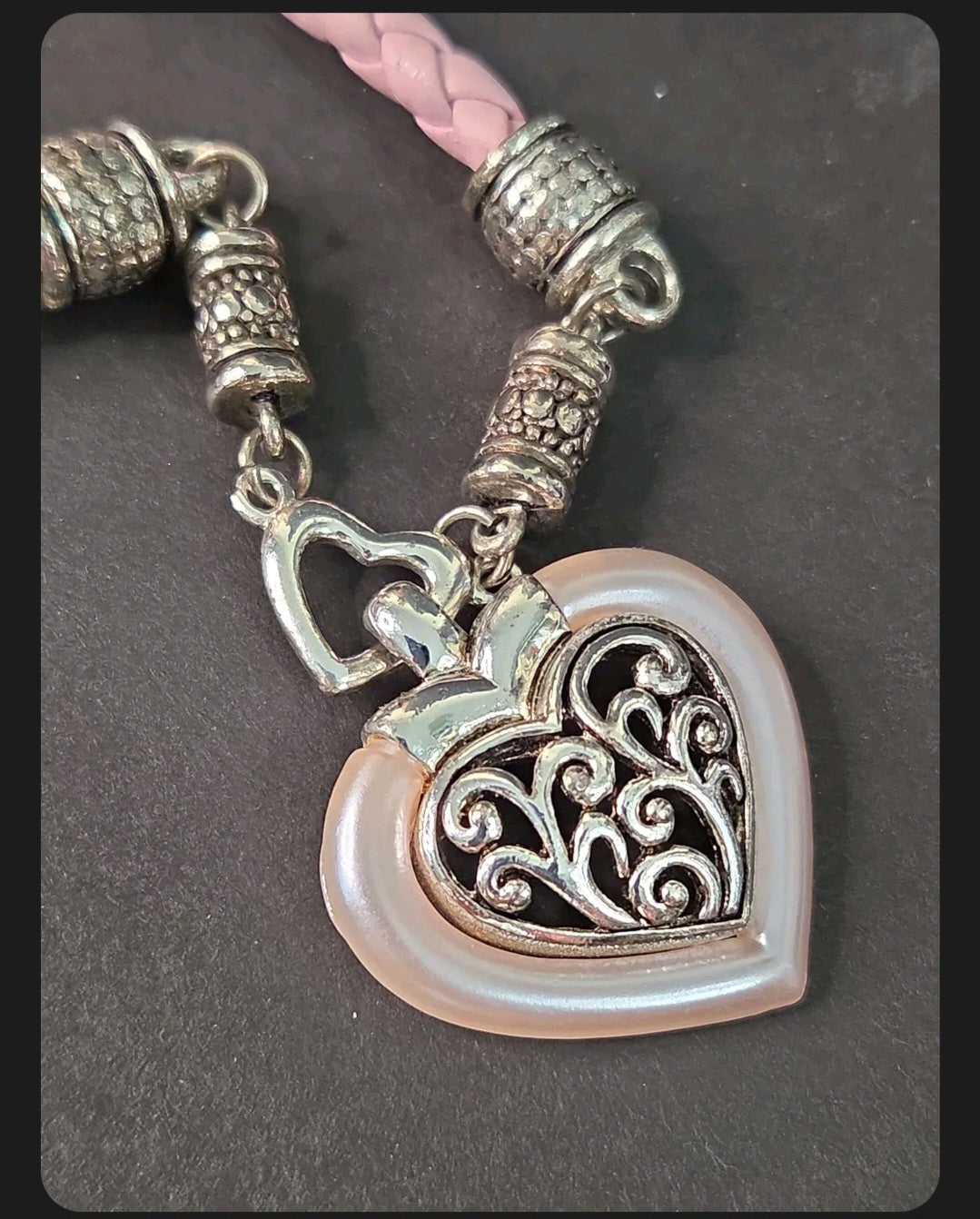 Oddly Darling Vintage heart pendant necklace with silver filigree, pearlescent pink border, and braided light pink cord.