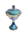 Oddly Darling Vintage iridescent blue carnival glass pedestal candy dish with embossed grape and vine motif and lid.