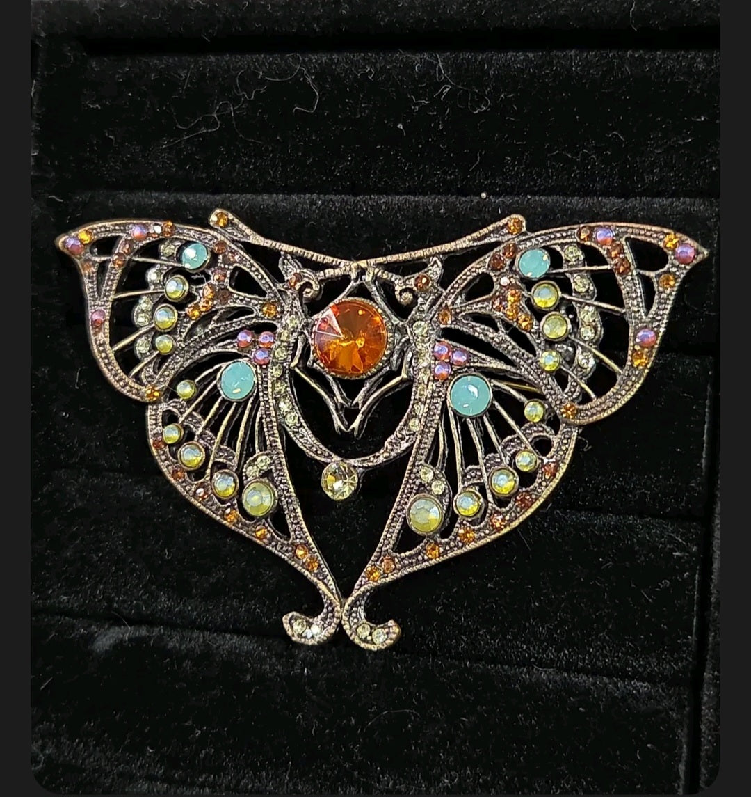 Oddly Darling Vintage ornate moth brooch in antique bronze with a central amber stone and multi-colored crystals.