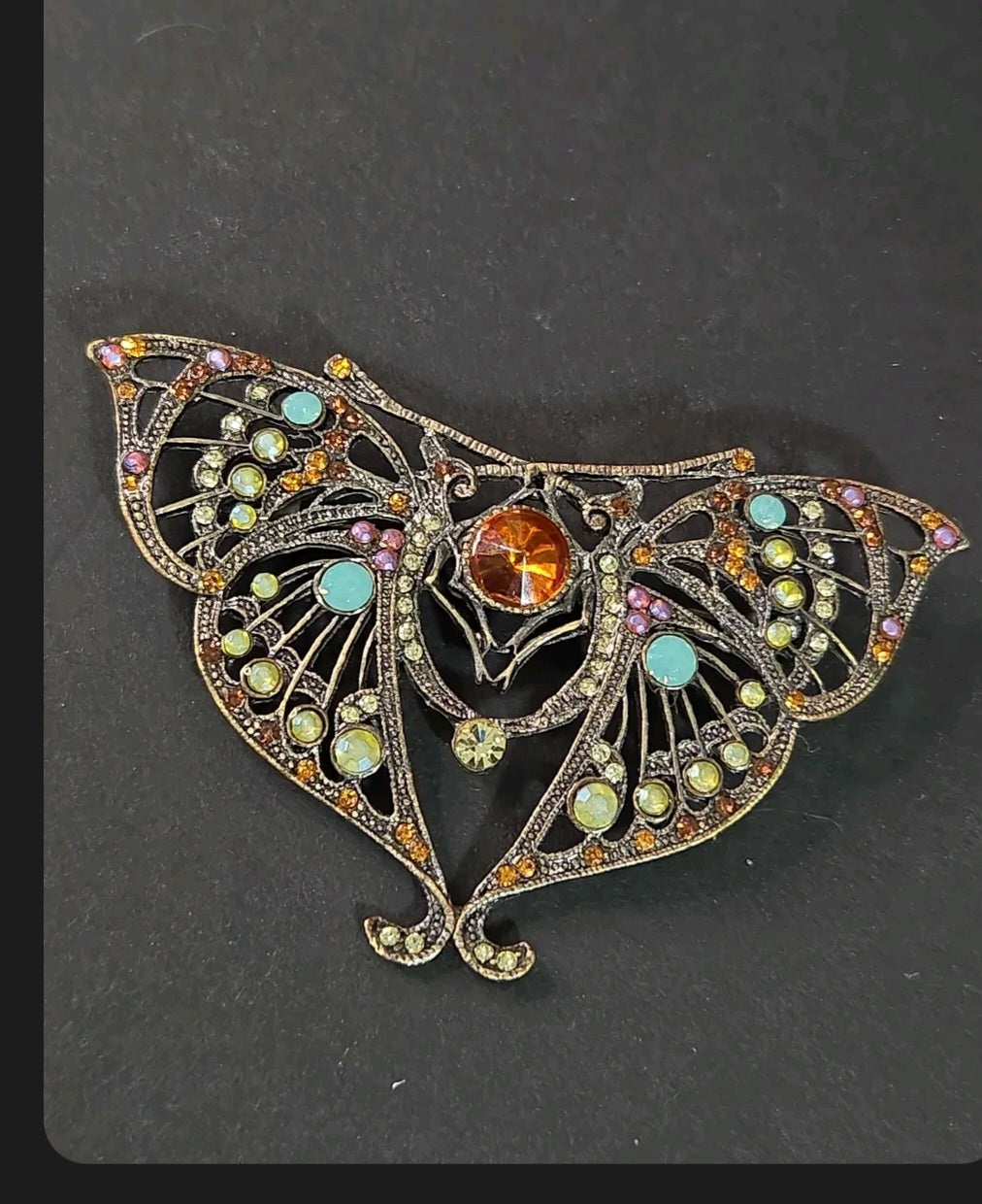 Oddly Darling Vintage ornate moth brooch in antique bronze with a central amber stone and multi-colored crystal accents