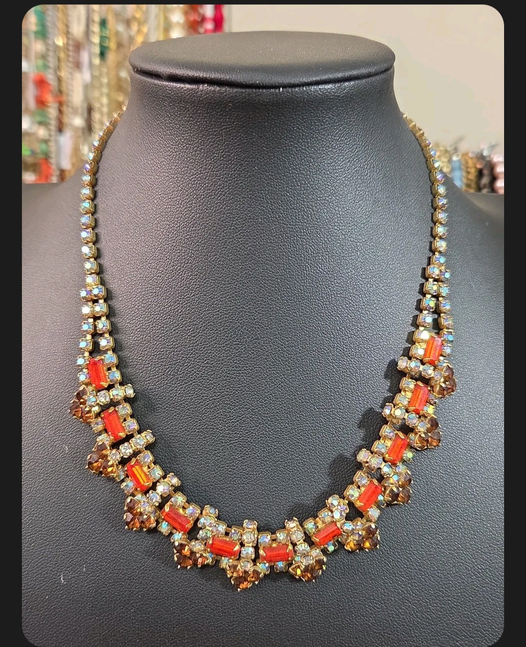 Oddly Darling Vintage statement necklace with orange and amber rhinestones in a gold-tone setting on a display bust.