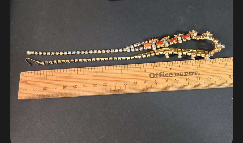 Oddly Darling Vintage gold-tone statement necklace with orange and iridescent rhinestones on a measuring ruler.