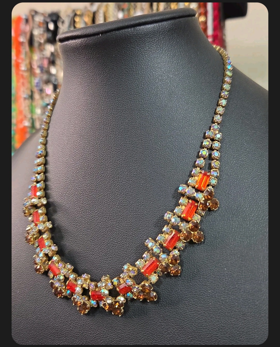 Oddly Darling Vintage statement necklace featuring orange and amber crystals with iridescent accents on gold-tone metal.