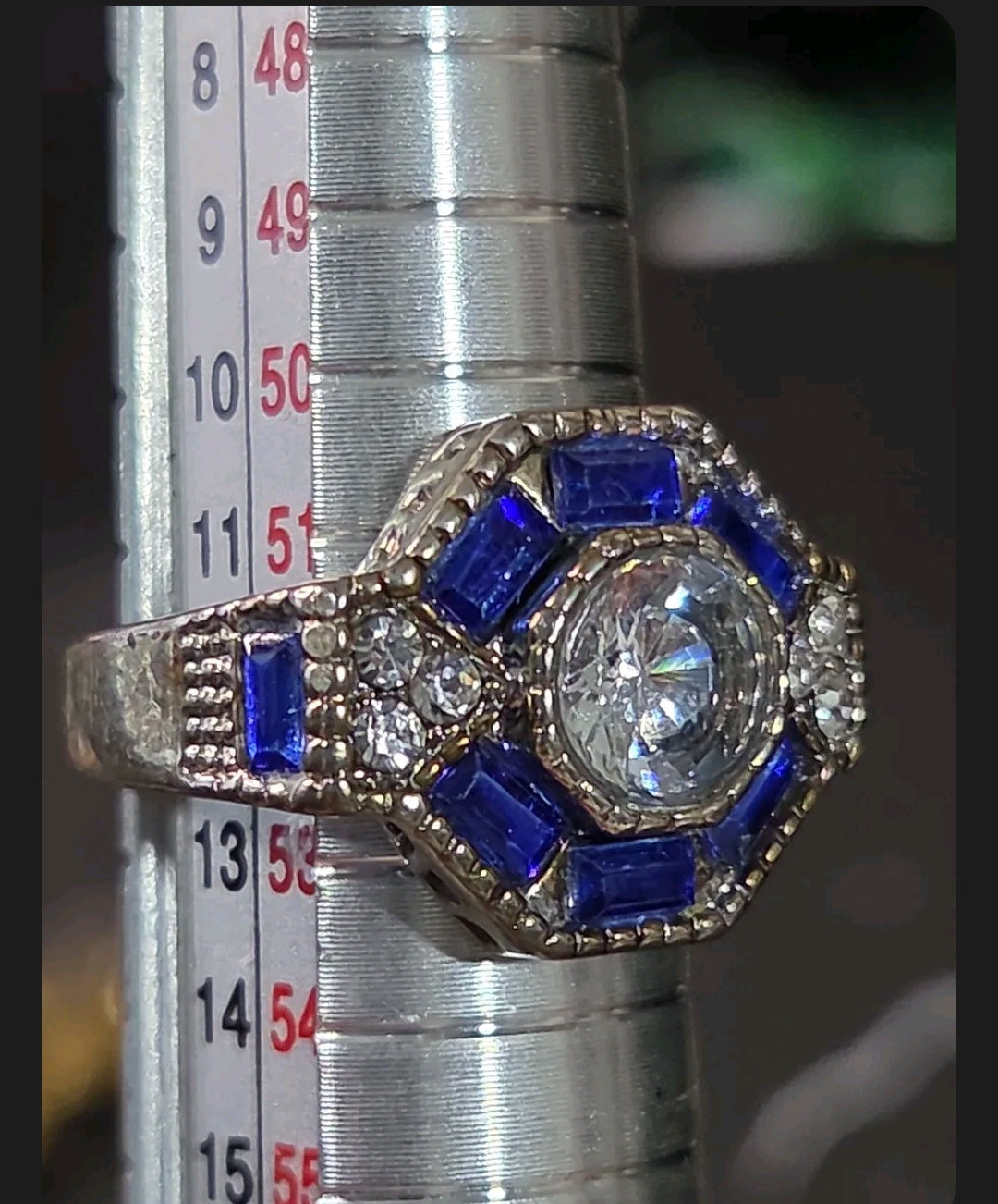 Oddly Darling Vintage ornate statement ring with a central round stone, blue baguette halo, and antique silver band.