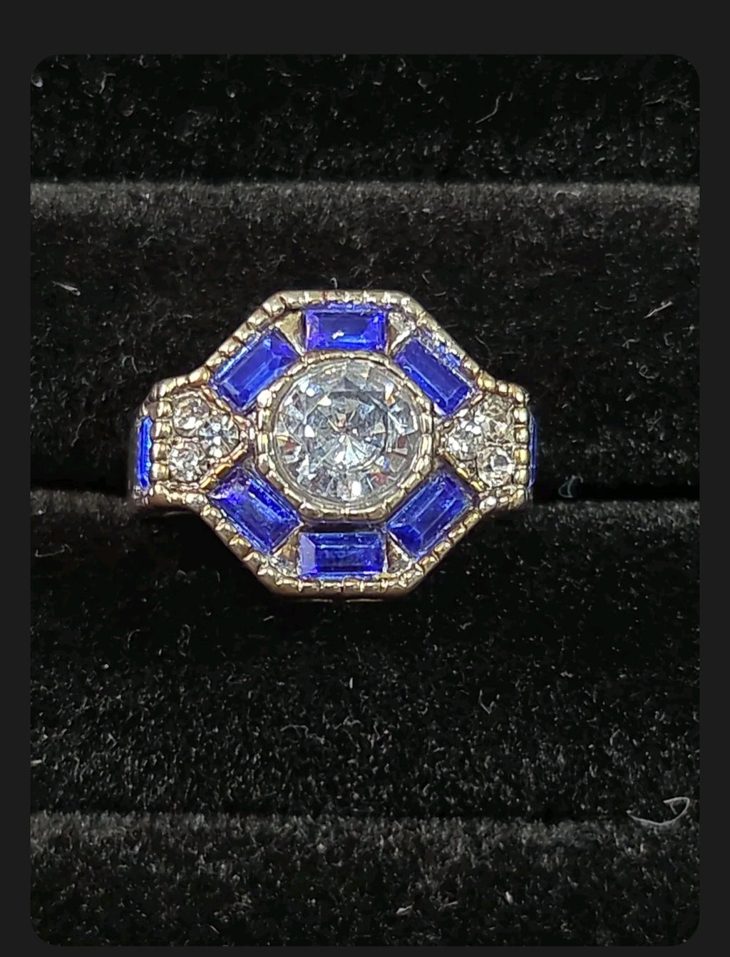 Oddly Darling Vintage ornate statement ring with a round central stone, blue baguette accents, and textured band.