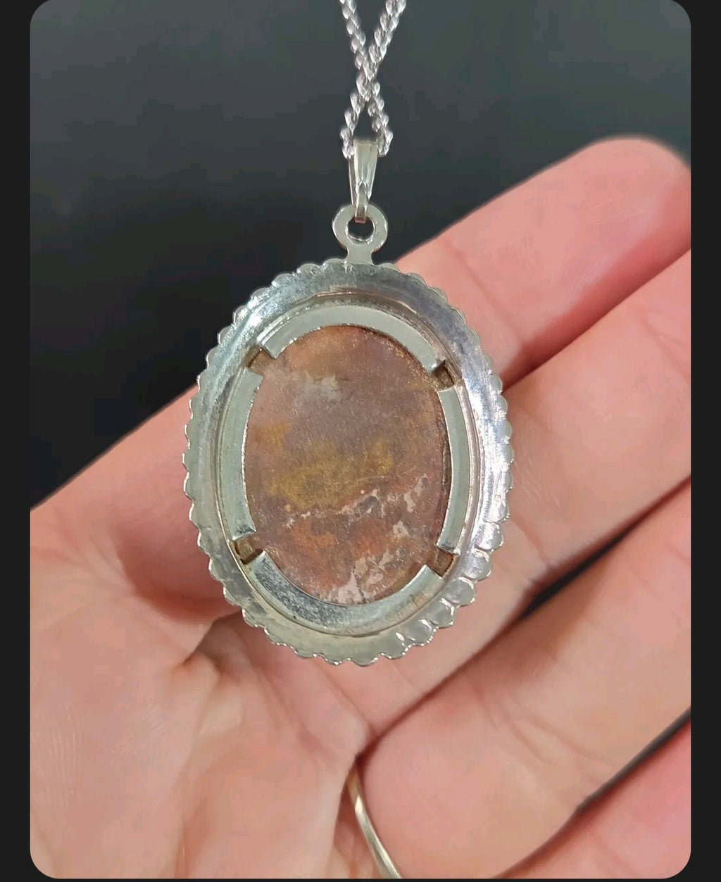 Oddly Darling Vintage oval agate pendant necklace featuring a silver-tone beaded frame held in a hand.