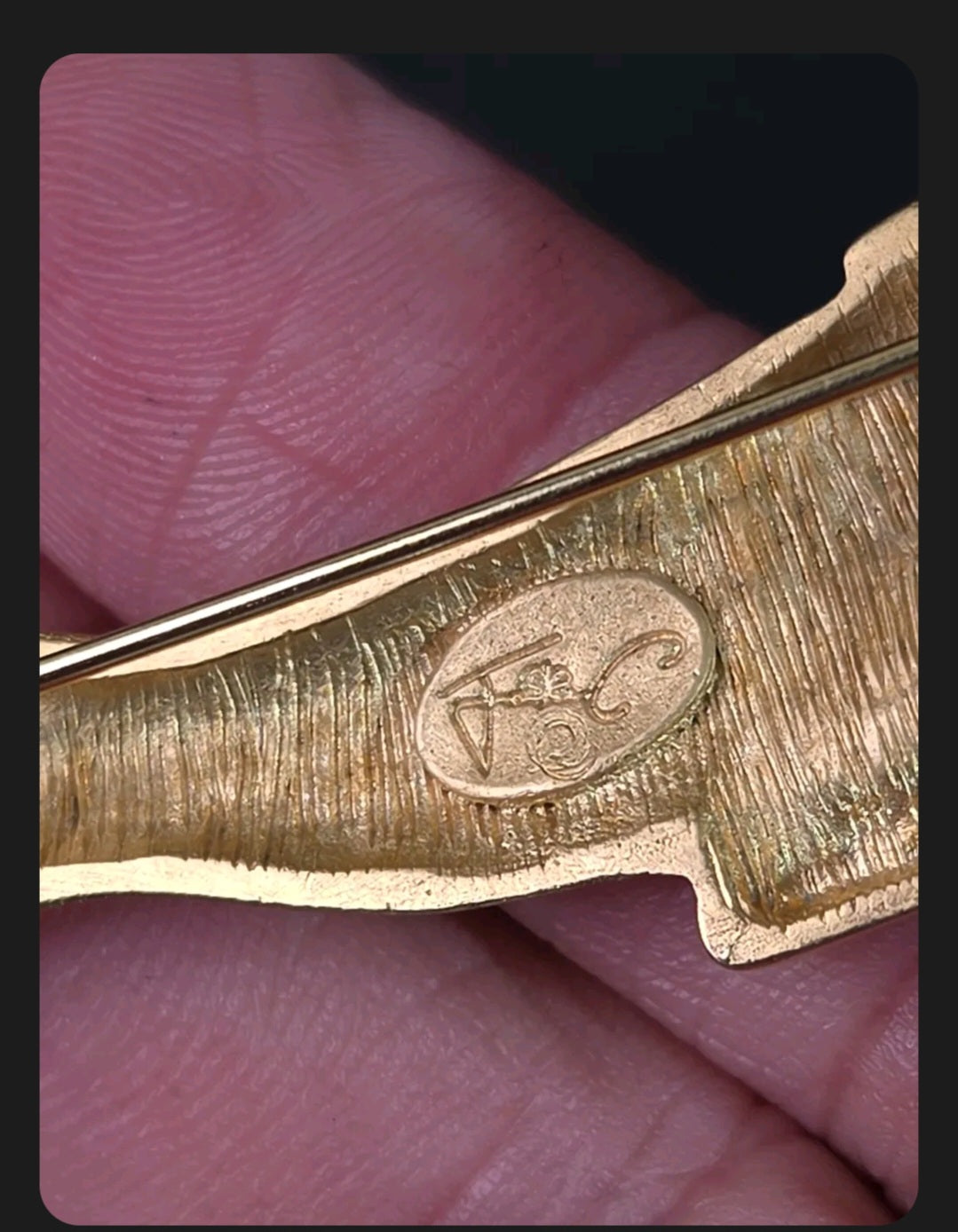 Oddly Darling Vintage gold-tone panther brooch showing the designer hallmark stamp on the textured metal back