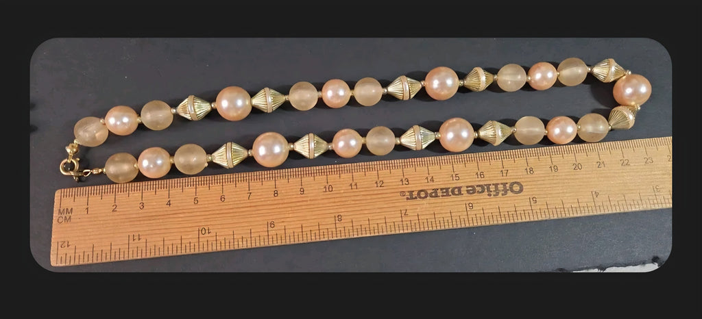 Oddly Darling Vintage statement necklace with peach faux pearls, frosted beads, and gold-tone fluted spacers on a ruler