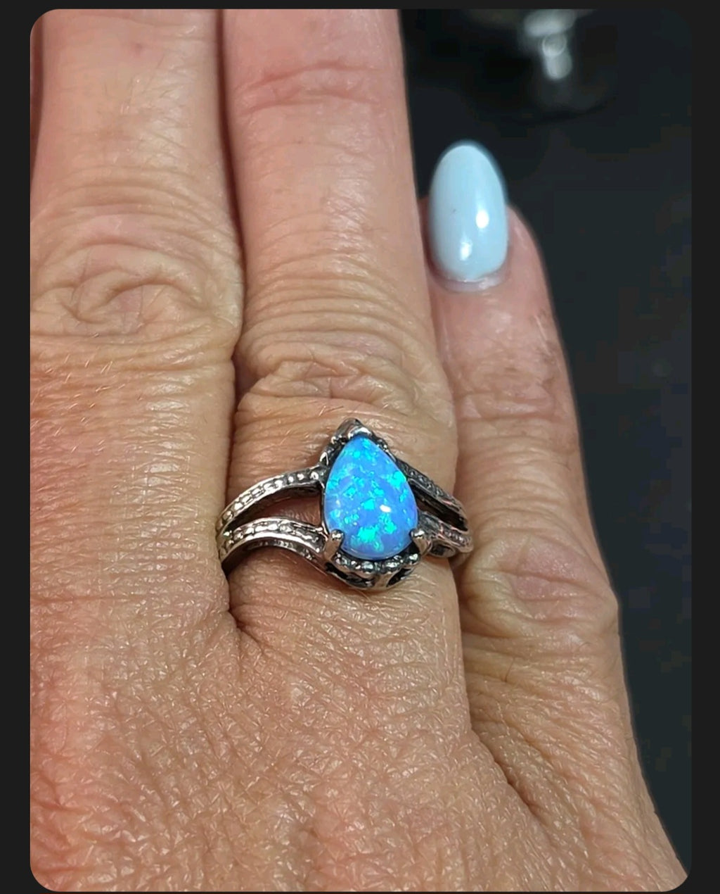 Oddly Darling Vintage pear-shaped blue opal statement ring with a textured silver-tone split-shank band on a finger.