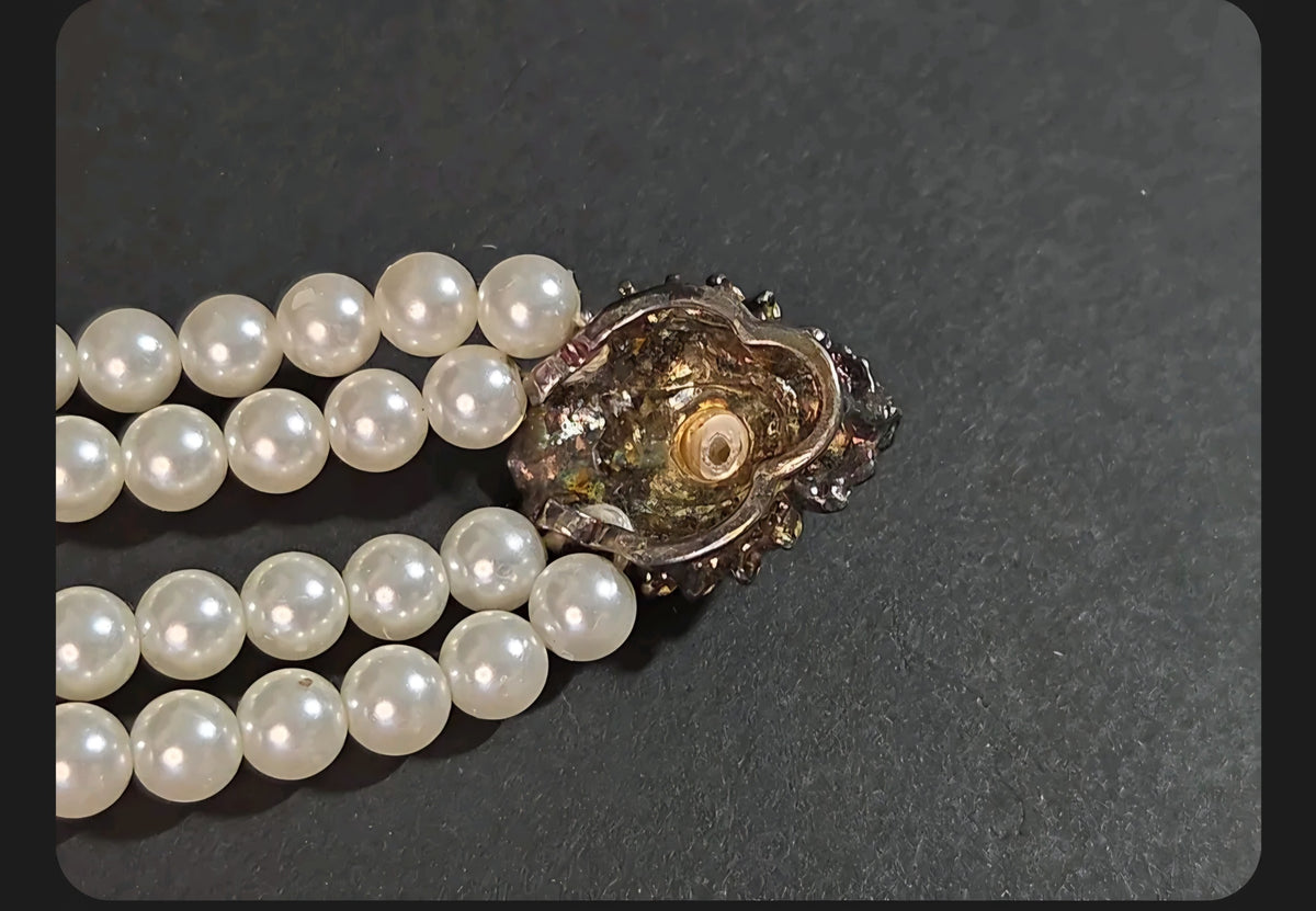 Oddly Darling Vintage double-strand cream faux pearl necklace with a detailed metal box clasp on a dark background.