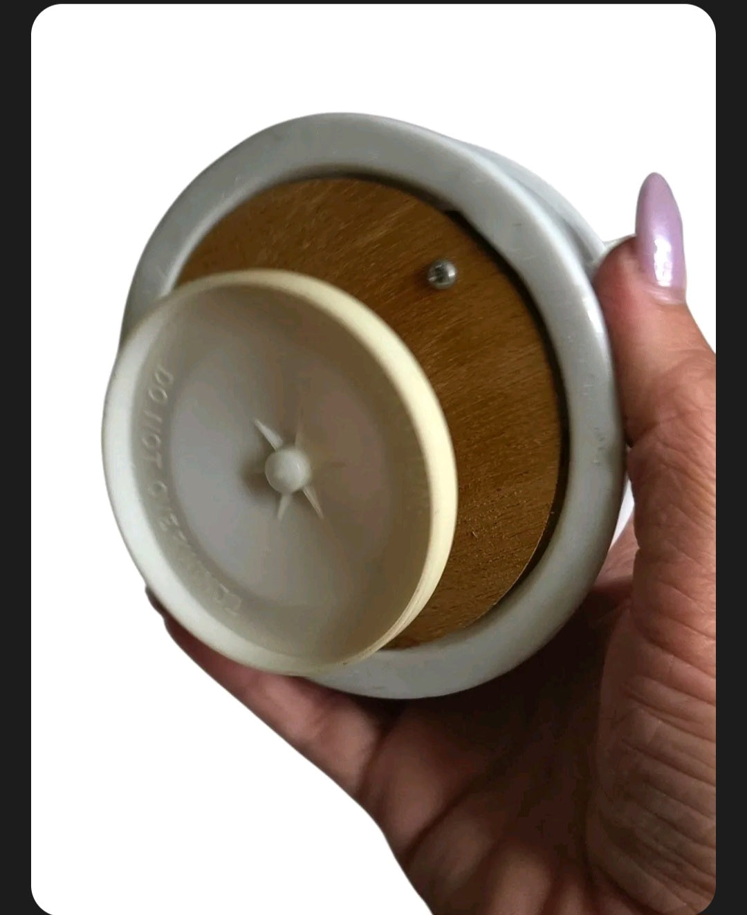 Oddly Darling Vintage porcelain music box base showing the wind-up mechanism and circular plastic stand