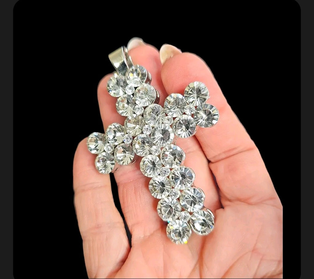 Oddly Darling Vintage rhinestone cross pendant with clear crystals set in a silver-tone base held in a hand