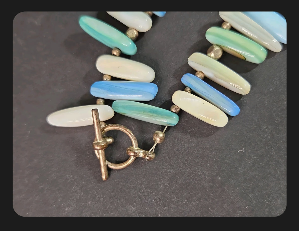 Oddly Darling Vintage statement necklace featuring elongated polished shell beads in ocean blue, green, and white tones.