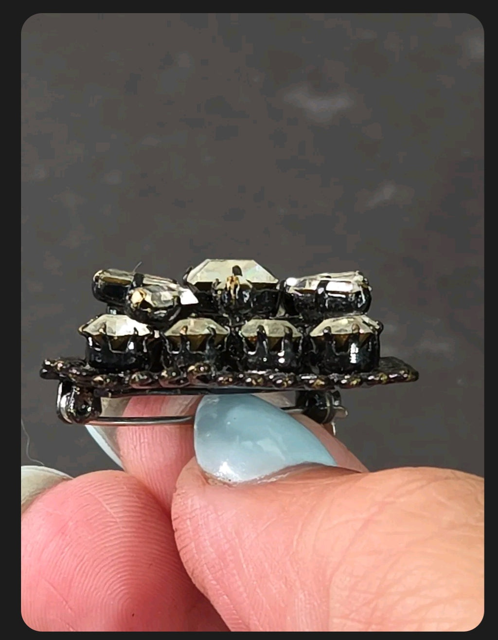 Oddly Darling Vintage square brooch with clear faceted crystals and gunmetal setting held between fingers