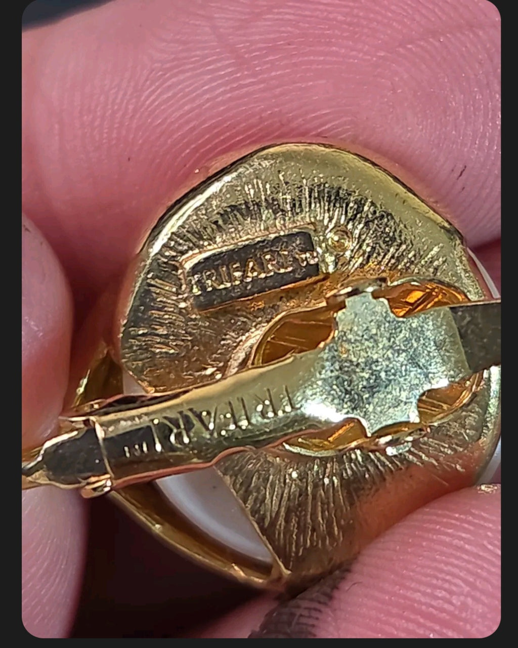 Oddly Darling Vintage Trifari clip-on earring back showing the signature stamp on the gold-tone metal setting