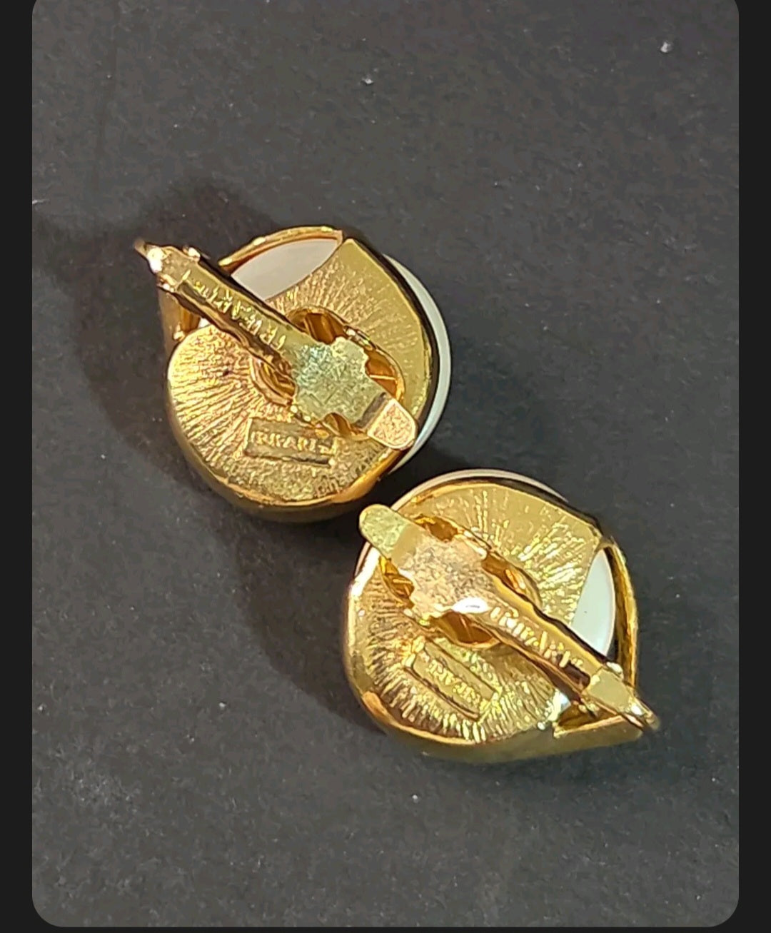 Oddly Darling Vintage Trifari clip-on earrings showing the gold-tone metal backs with signature Trifari branding